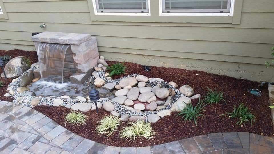 Decorative landscape water feature with rock and plants