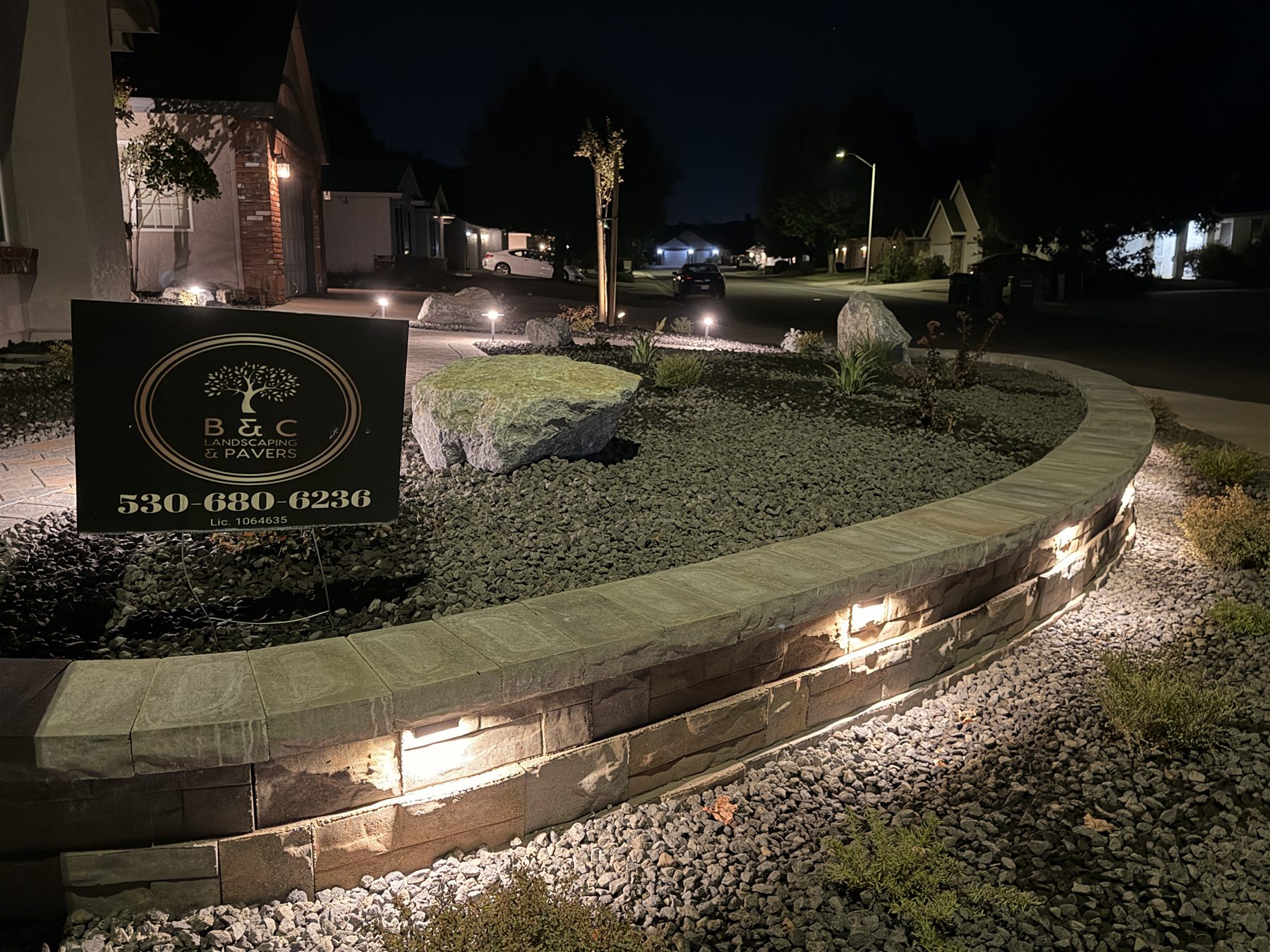 Night lighting installed along a curved retaining wall