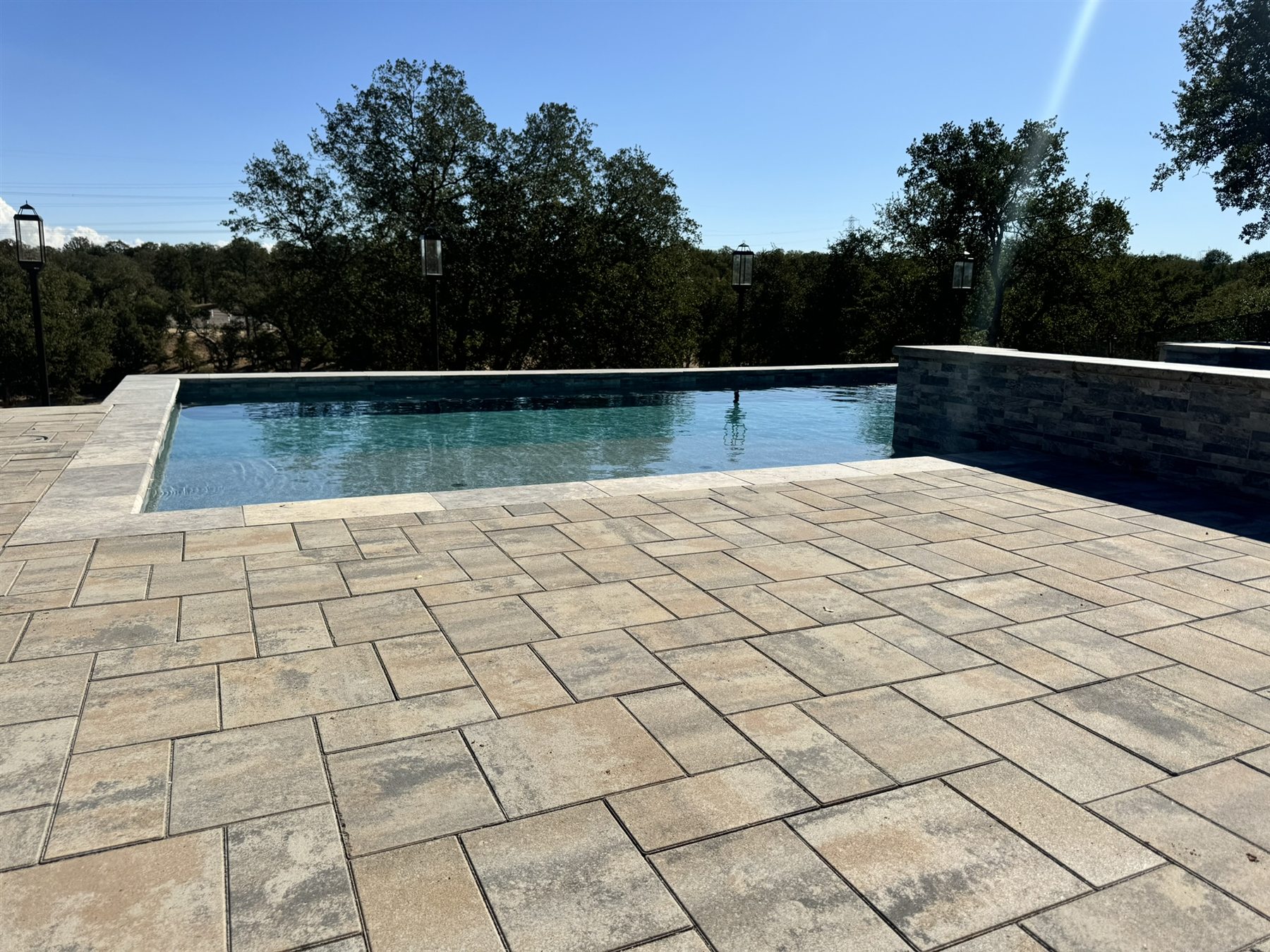 Finished paver deck beside a swimming pool