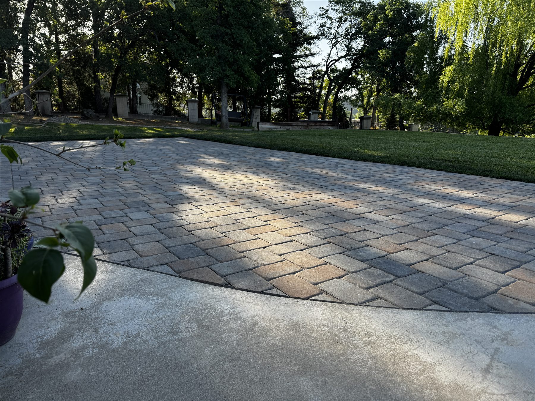 Finished paver patio beneath mature trees