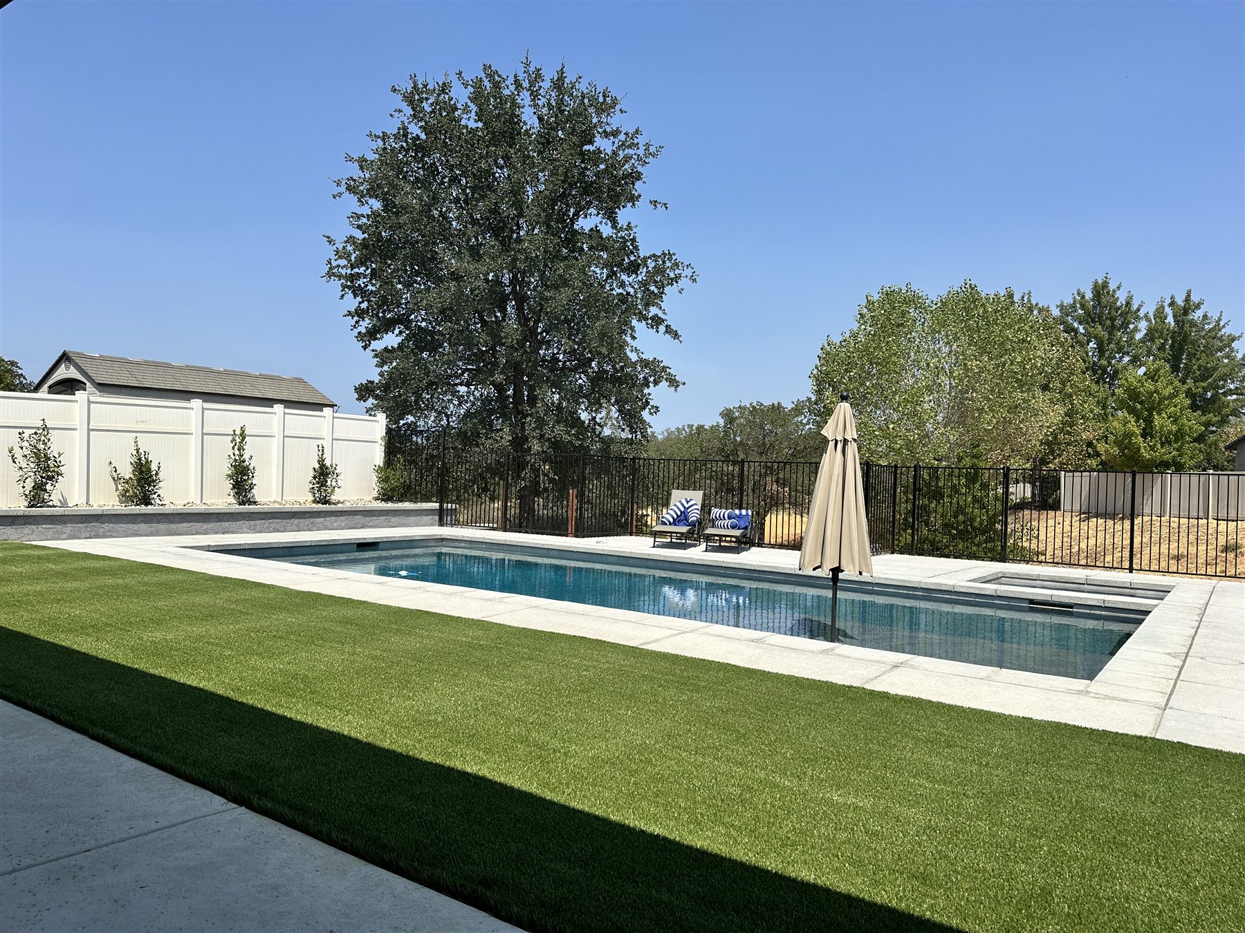 B&C artificial turf installation surrounding a backyard pool