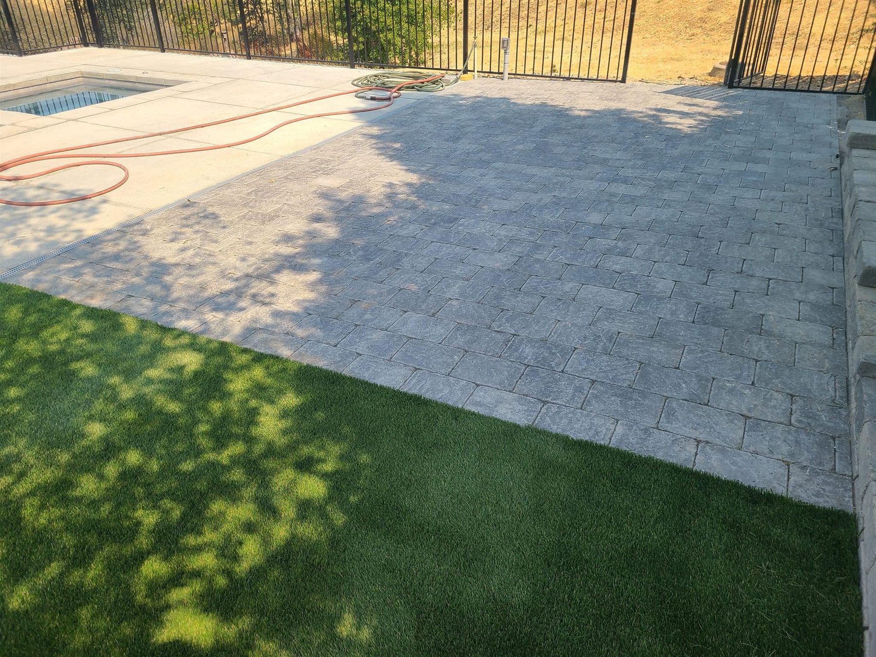 Artificial turf beside a finished paver patio