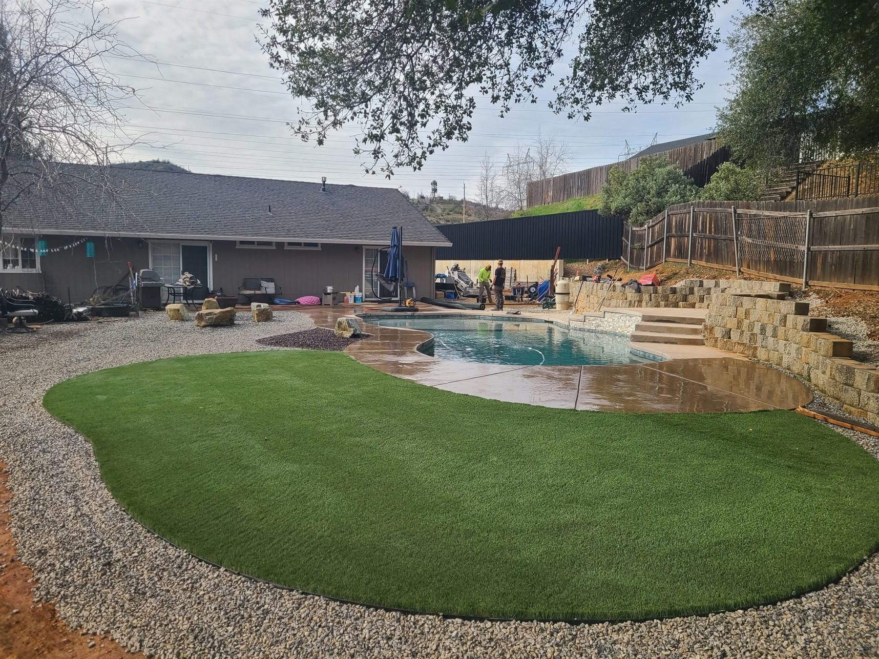 Curved artificial turf lawn beside a pool
