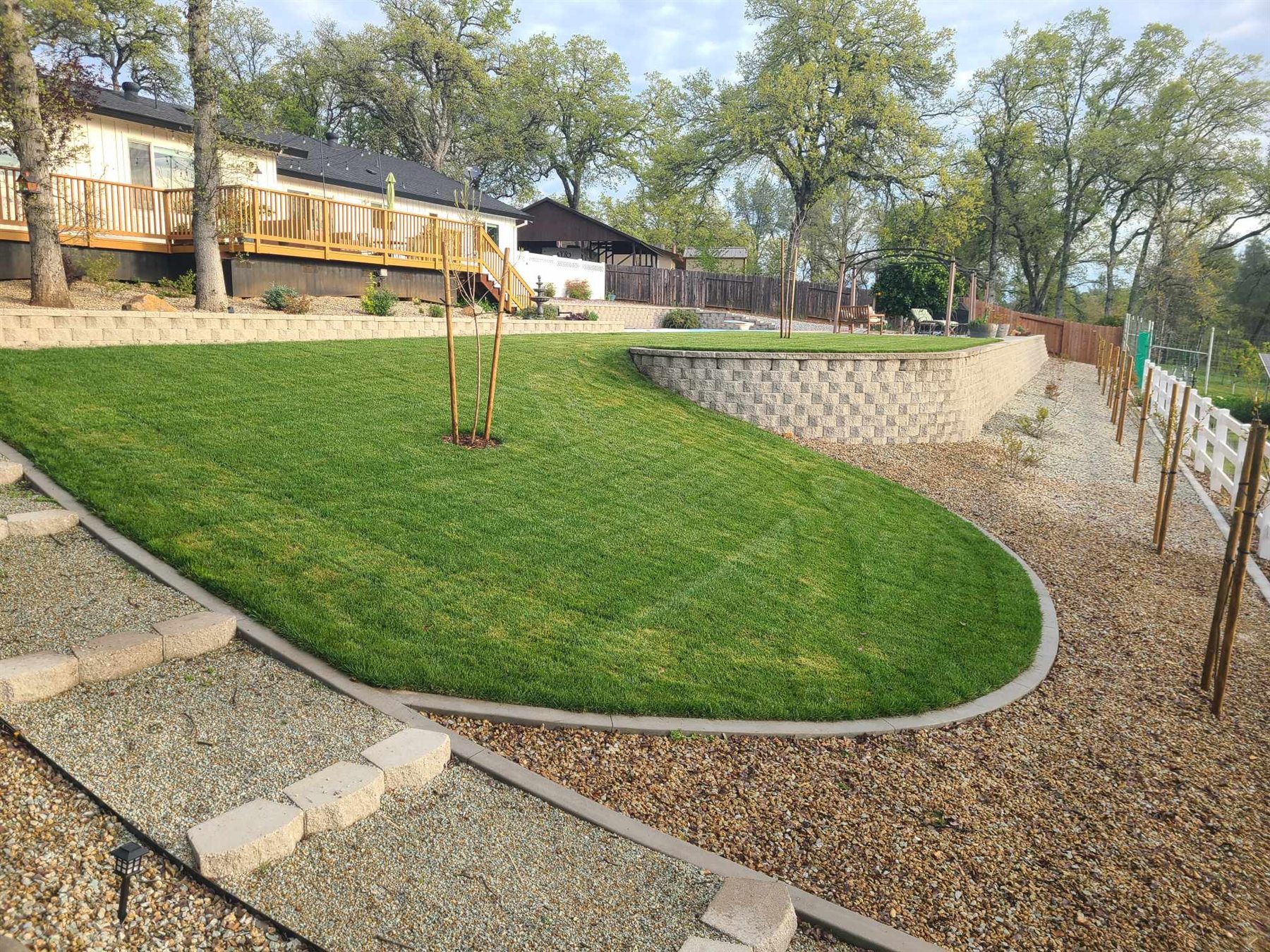 Finished lawn with a retaining wall and concrete mow strip
